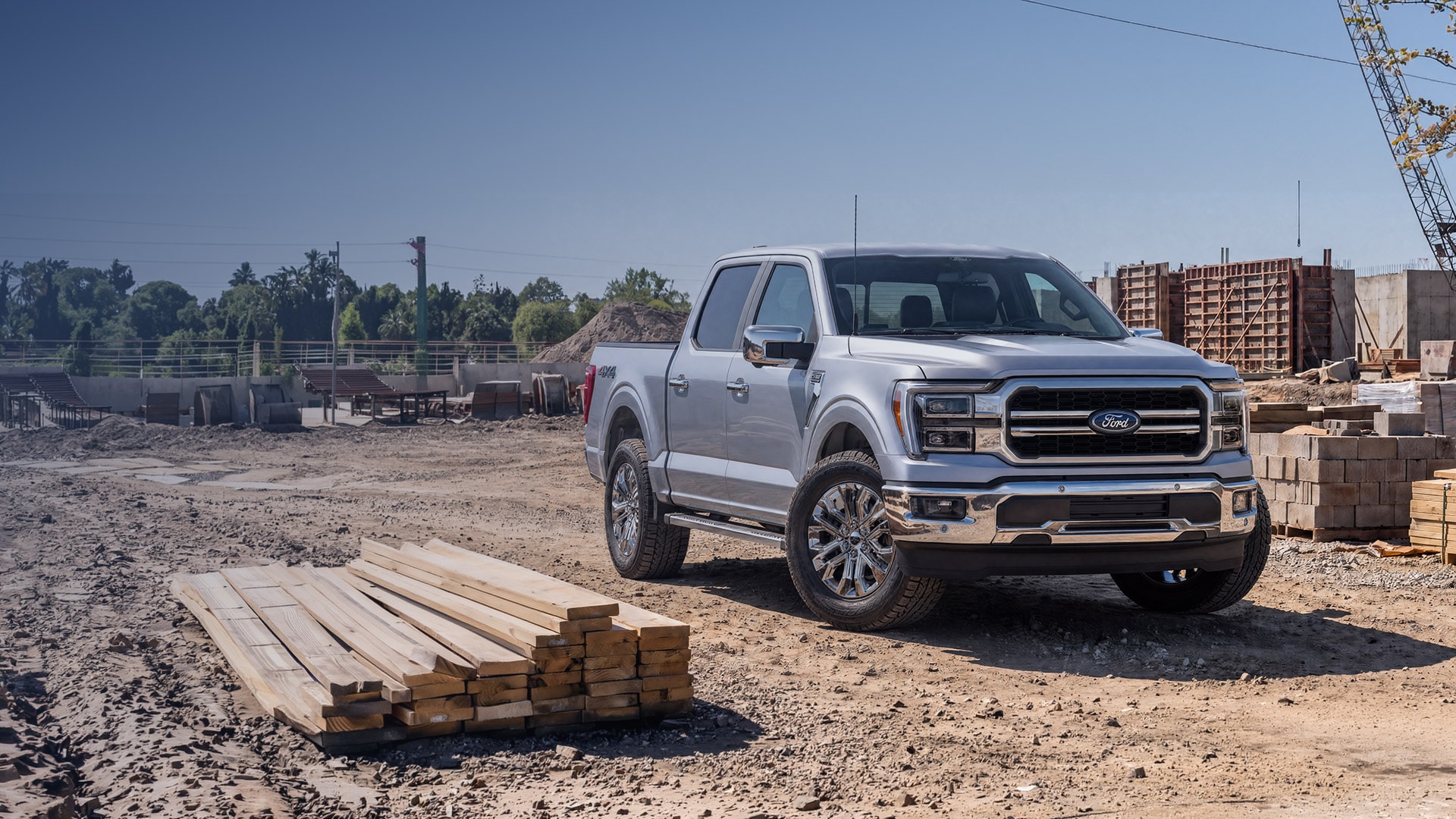 Nueva Ford F-150 plateada en vista frontal de tres cuartos en una zona de construcción.