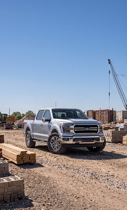 Nueva Ford F-150 plateada en vista frontal de tres cuartos en una zona de construcción.