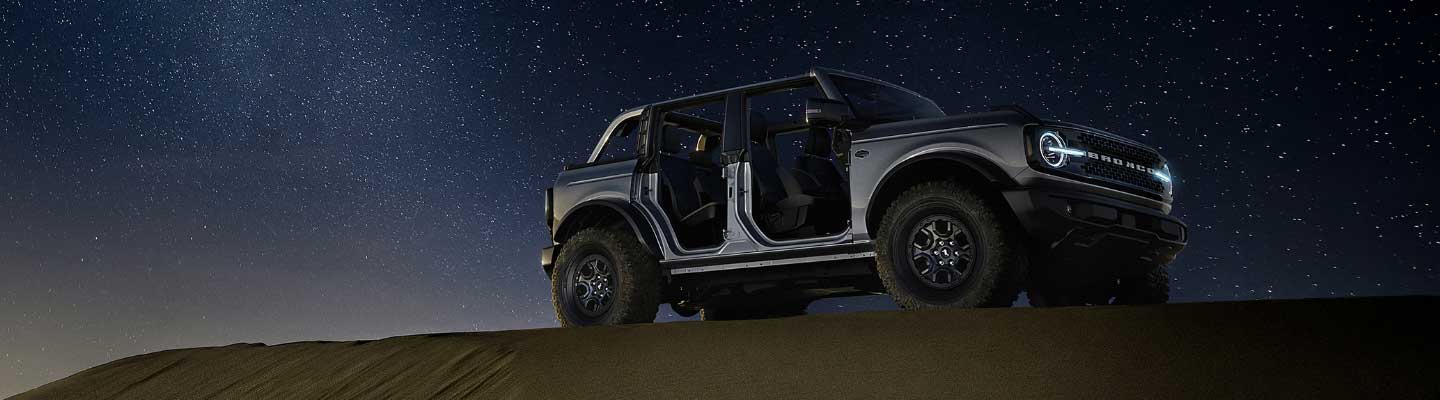 Nueva Bronco en la noche con techo y puertas desmontadas